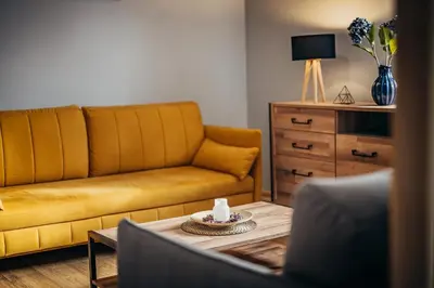 a living room with a couch and a table at Gościniec pod Lilijką in Podzamcze