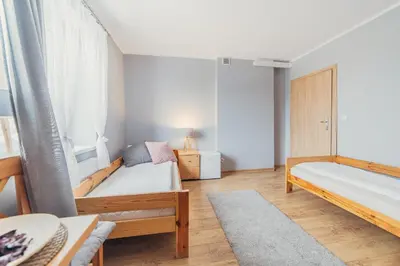 a small bedroom with two beds and a table at Gościniec pod Lilijką in Podzamcze