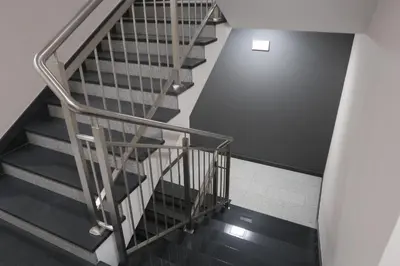 a staircase with a metal railing and a stair case at Room Tour Rakowicka 14a in Kraków
