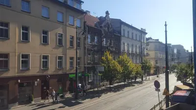 a city street with buildings and people walking on the street at Room Tour Rakowicka 14a in Kraków