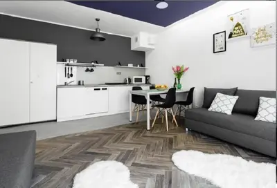 a kitchen and a living room with a couch and a table at Room Tour Rakowicka 14a in Kraków