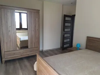 a bedroom with a bed and a large wooden cabinet at Cicha Chata Kudłacze in Pcim