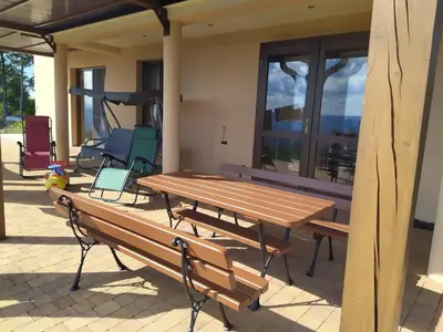 a picnic table and chairs on a patio at Cicha Chata Kudłacze in Pcim