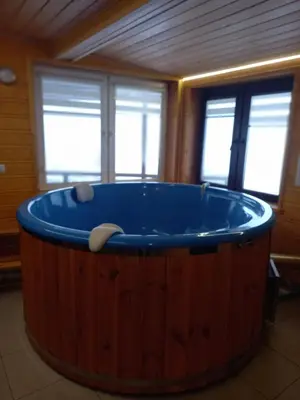 a large wooden tub in a room with windows at Cicha Chata Kudłacze in Pcim