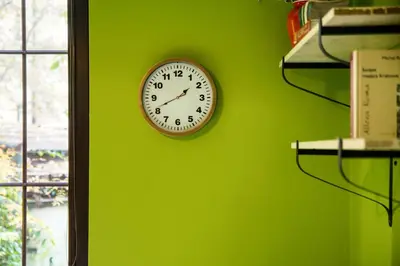 a clock on a green wall next to a window at Art Pop in Cracow in Kraków