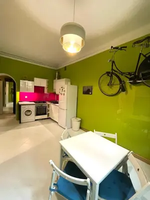 a room with a green wall with a bike hanging on the wall at Art Pop in Cracow in Kraków