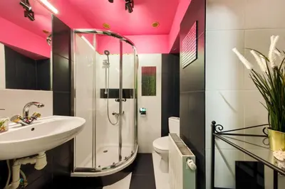 a bathroom with a sink and a shower with pink ceilings at Art Pop in Cracow in Kraków