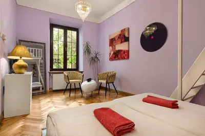 a bedroom with purple walls and a bed and chairs at Art Pop in Cracow in Kraków
