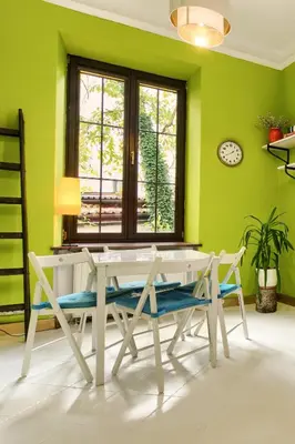a dining room with green walls and a table and chairs at Art Pop in Cracow in Kraków