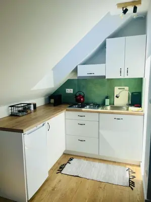 a kitchen with white cabinets and a blue roof at Zakątek Solny in Bochnia