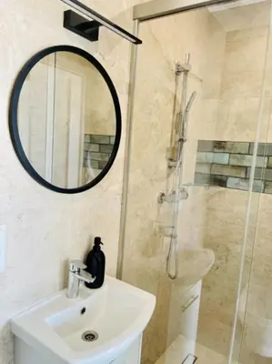 a bathroom with a sink and a shower with a mirror at Zakątek Solny in Bochnia