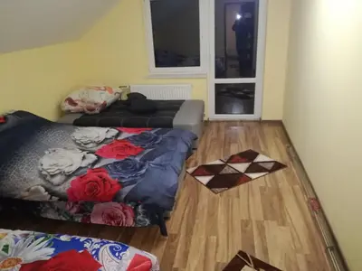 a room with a bed with roses on it at Apartament u Wioli in Okleśna
