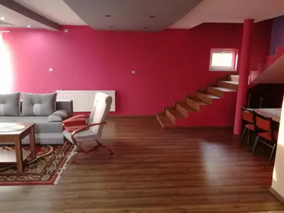 a living room with a couch and a red wall at Apartament u Wioli in Okleśna