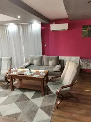 a living room with a couch and a table and chairs at Apartament u Wioli in Okleśna