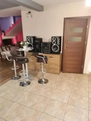 a kitchen with a counter with stools and a bar at Apartament u Wioli in Okleśna