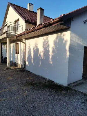 a white building with a shadow of trees on it at Apartament u Wioli in Okleśna