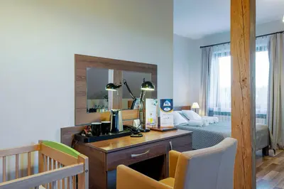 a room with a desk and a bedroom with a bed at Hotel Łokietek in Czajowice