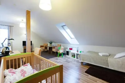 a bedroom with a bed and a crib in a room at Hotel Łokietek in Czajowice