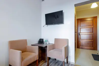 a room with a table and two chairs and a television at Hotel Łokietek in Czajowice