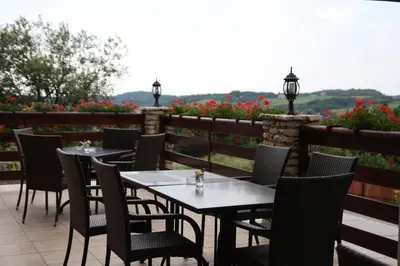a row of tables and chairs on a patio with flowers at Hotel Łokietek in Czajowice