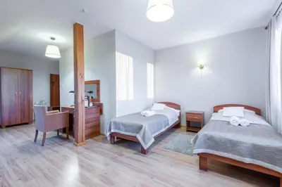 a hotel room with two beds and a desk at Hotel Łokietek in Czajowice