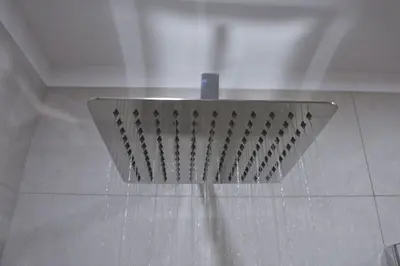 a shower head in a bathroom with water on the floor at BOUTIQUE 108 - old city, luxury apt. with a garage in Kraków