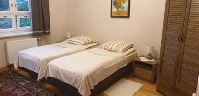 two beds sitting next to each other in a bedroom at Dom Gościnny Wisteria in Andrychów