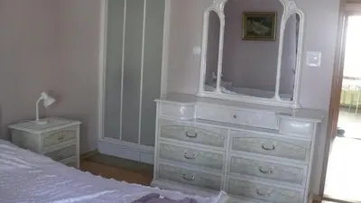 a bedroom with a white dresser with a mirror at Dom Gościnny Wisteria in Andrychów