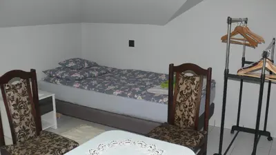 a bedroom with a bed with two chairs and a table at Dom Gościnny Wisteria in Andrychów