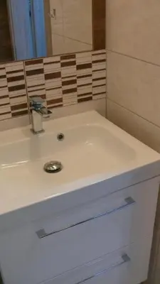 a bathroom with a white sink and a mirror at Dom Gościnny Wisteria in Andrychów