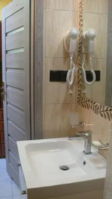 a bathroom with a white sink and a mirror at Dom Gościnny Wisteria in Andrychów