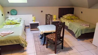 a bedroom with two beds and a chair in it at Dom Gościnny Wisteria in Andrychów