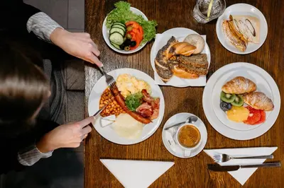 a table with plates of breakfast food on it at Hotel Yarden by Artery Hotels in Kraków