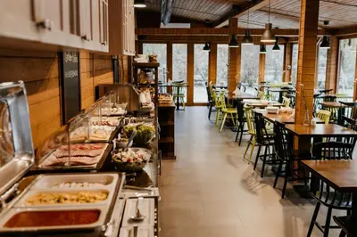 a restaurant with a buffet line with tables and chairs at Hotel Yarden by Artery Hotels in Kraków
