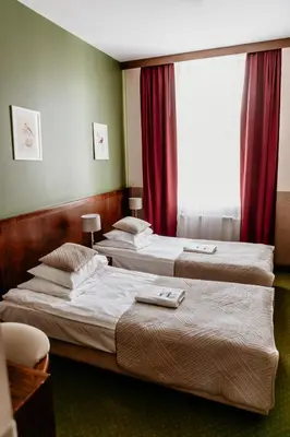 two beds in a hotel room with a window at Hotel Yarden by Artery Hotels in Kraków
