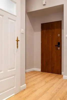 a door in an empty room with a wooden floor at HOUSEHOST Apartment: Łazarza II street in Kraków
