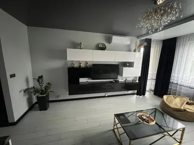 a living room with a couch and a table and a tv at Apartament Lema Versace in Kraków