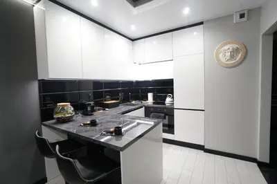 a kitchen with black and white walls and a counter at Apartament Lema Versace in Kraków