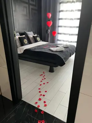 a bedroom with a bed with red hearts on the floor at Apartament Lema Versace in Kraków