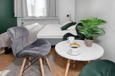 a bedroom with a bed and a table and chairs at Rainbow Apartments 3 in Kraków