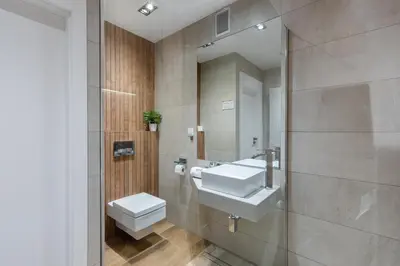 a bathroom with a sink and a toilet and a mirror at Rainbow Apartments 3 in Kraków
