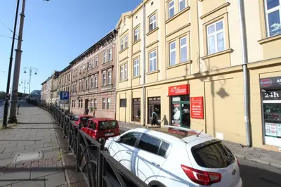 a white car parked in front of a building at Rainbow Apartments 3 in Kraków