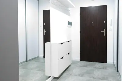 a room with white cabinets and a brown door at Republiki Korczakowskiej Ferienwohnung in Kraków