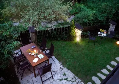 a backyard with a wooden table and chairs in the grass at Ojców Bazar Lwowski in Ojców