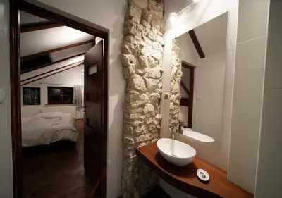 a bathroom with a sink and a room with a bed at Ojców Bazar Lwowski in Ojców