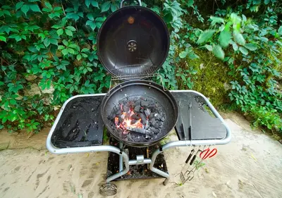 a grill with a fire in it in the sand at Ojców Bazar Lwowski in Ojców