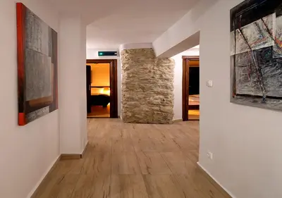 a hallway with a stone wall and paintings on the walls at Ojców Bazar Lwowski in Ojców