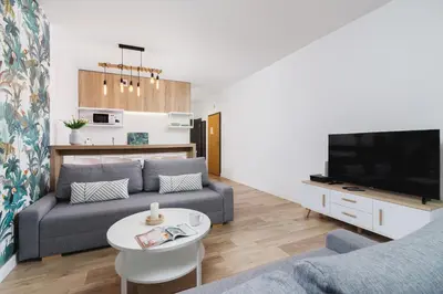 a living room with a couch and a tv at Apartament 3d GO by Noclegi Renters in Kraków