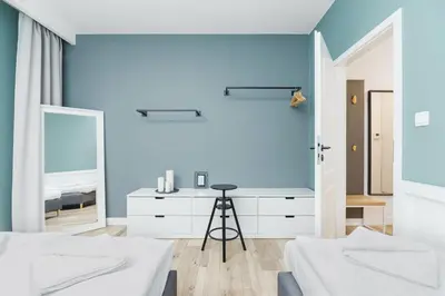 a bedroom with two beds and a blue wall at Apartament 3d GO by Noclegi Renters in Kraków