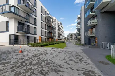 an empty street in front of apartment buildings at Apartments Cracow Rakowicka by Noclegi Renters in Kraków